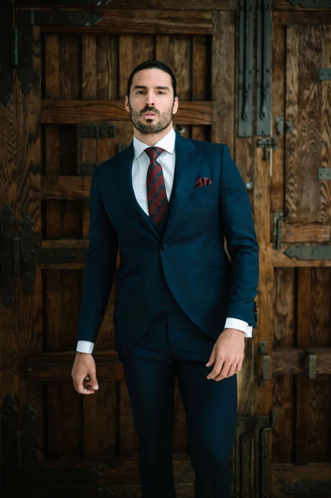 Chaque azul moderno modelo Reda 2026 de Guillermo Villanueva, traje de novio elegante en azul marino con cuadros.