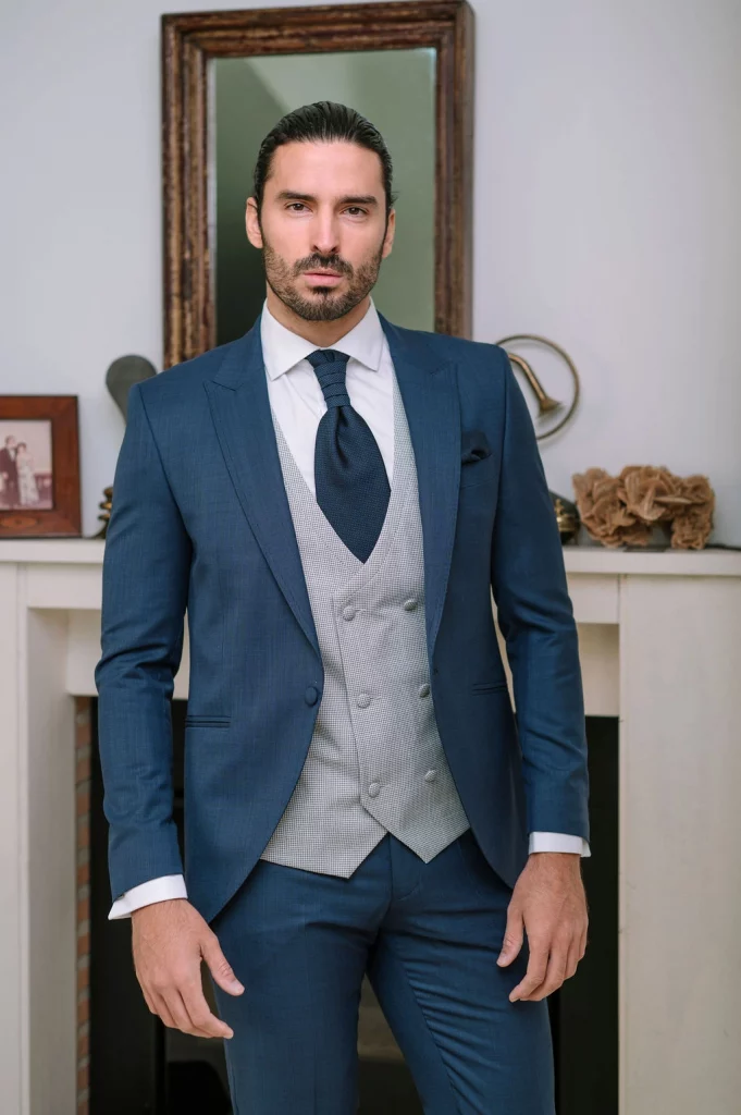 Traje de novio azul elegante Saturno 2026 – detalle chaleco y corbatón y pañuelo del mismo tejido del traje